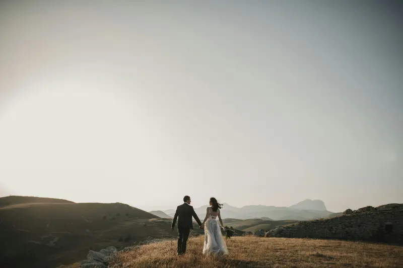A couple walking hand in hand across the hills